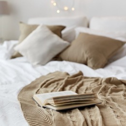 a bed with a book and pillows