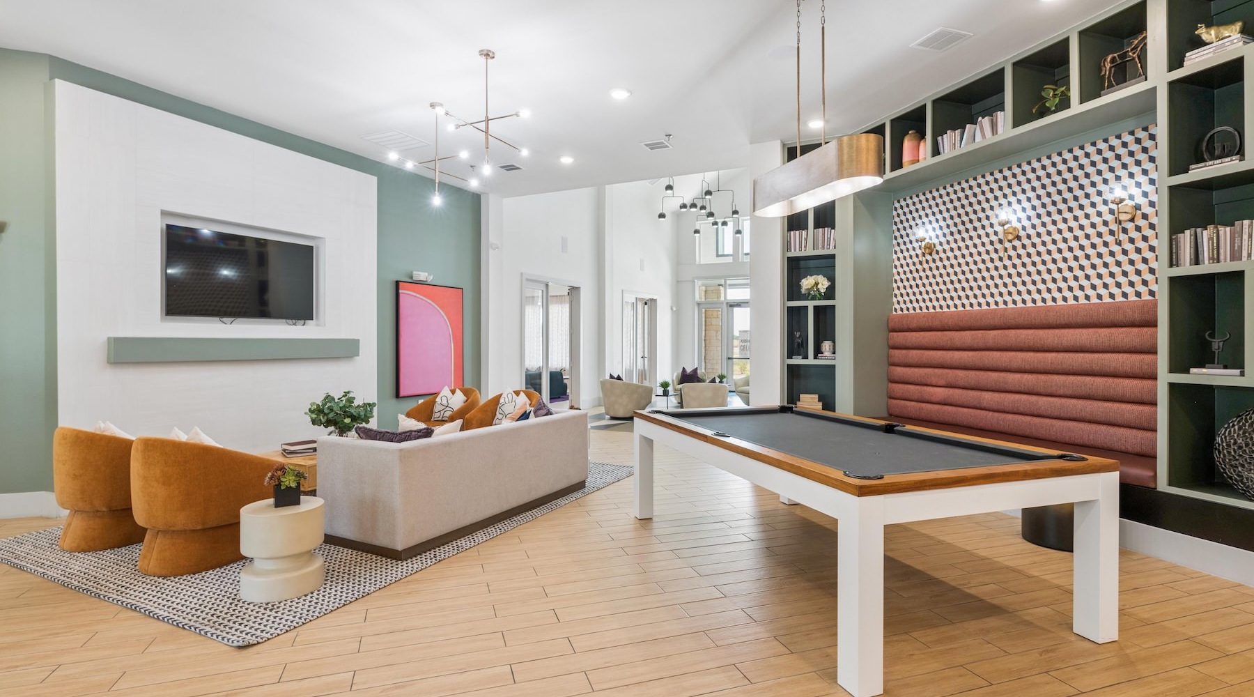 a clubroom with a pool table, tv and couch